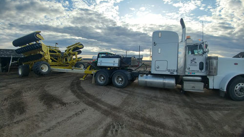 semi transporting farm equipment